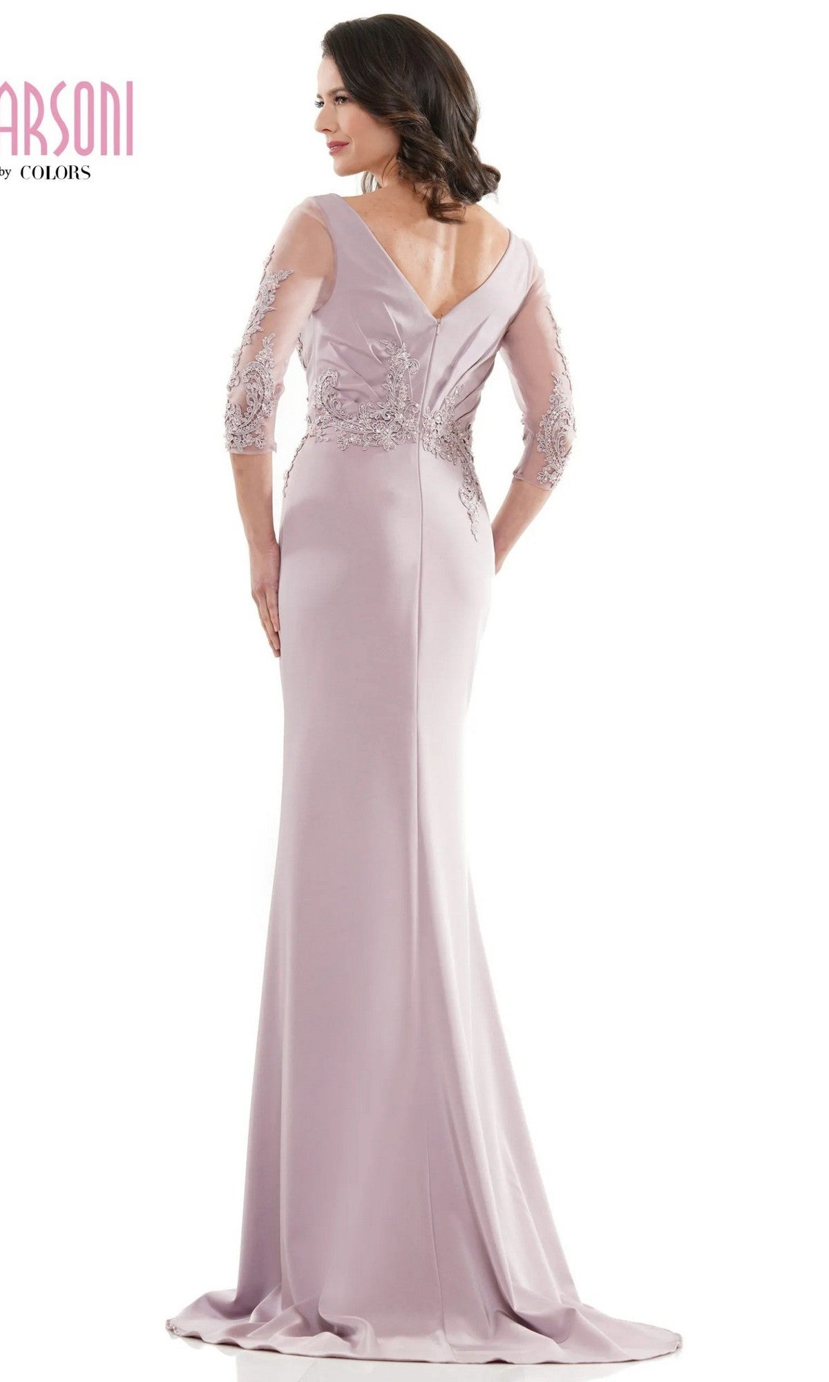A woman is seen from the back wearing the Marsoni MV1145 long formal dress in light mauve, featuring three-quarter sheer sleeves, floral embroidery, and delicate beaded embellishments.